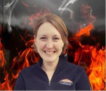 Crew member Susan standing against fake fire backdrop