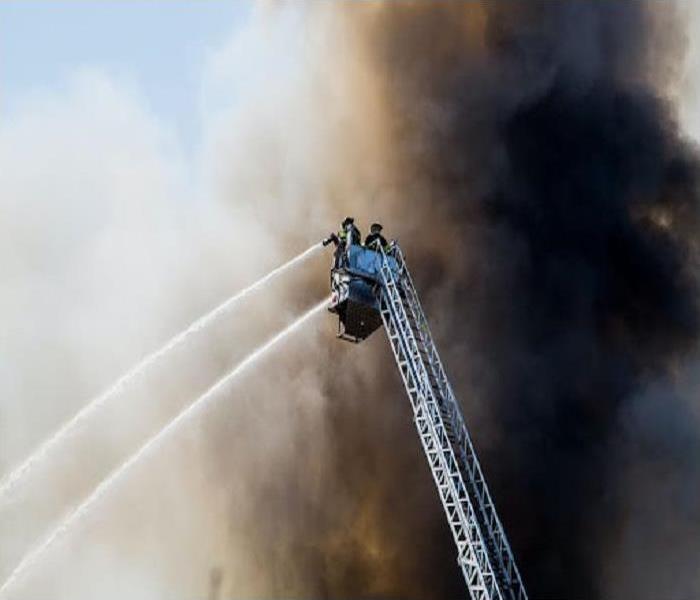 Firefighter spraying water onto fire